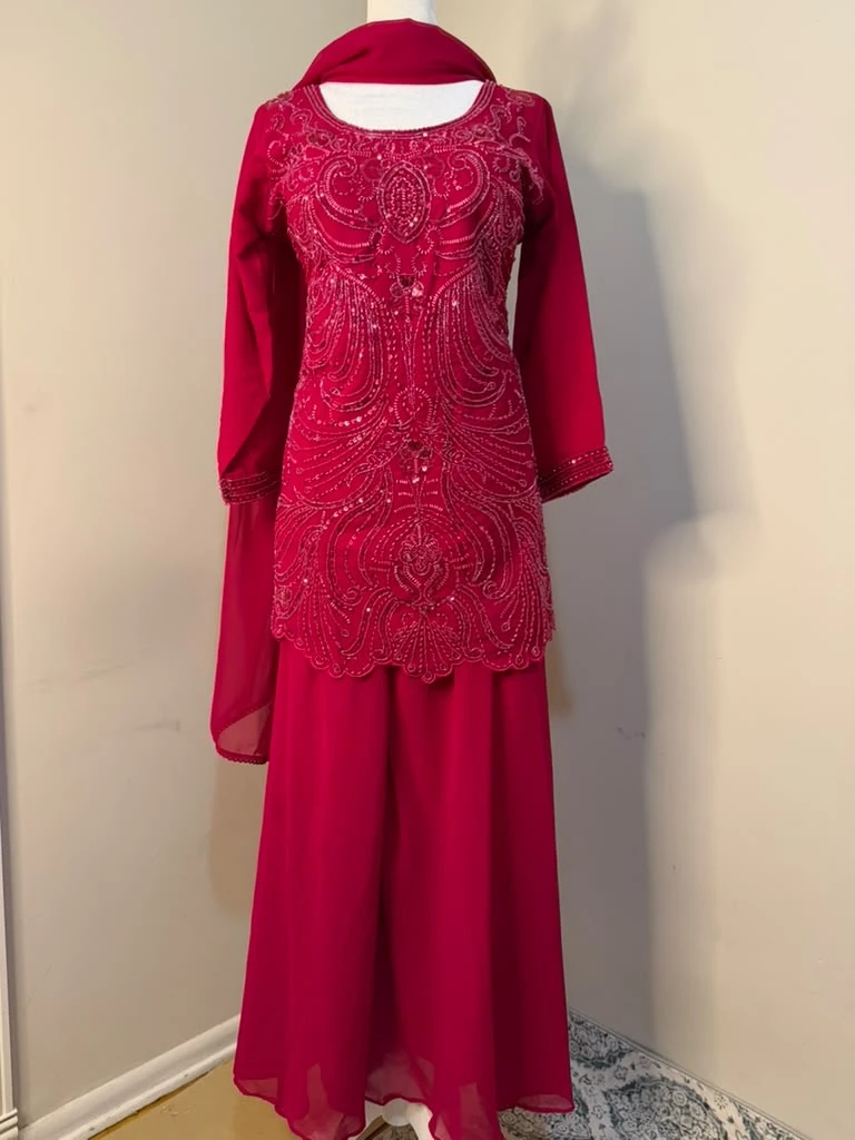 Front view of the crimson outfit with dense paisley-pattern embellishment