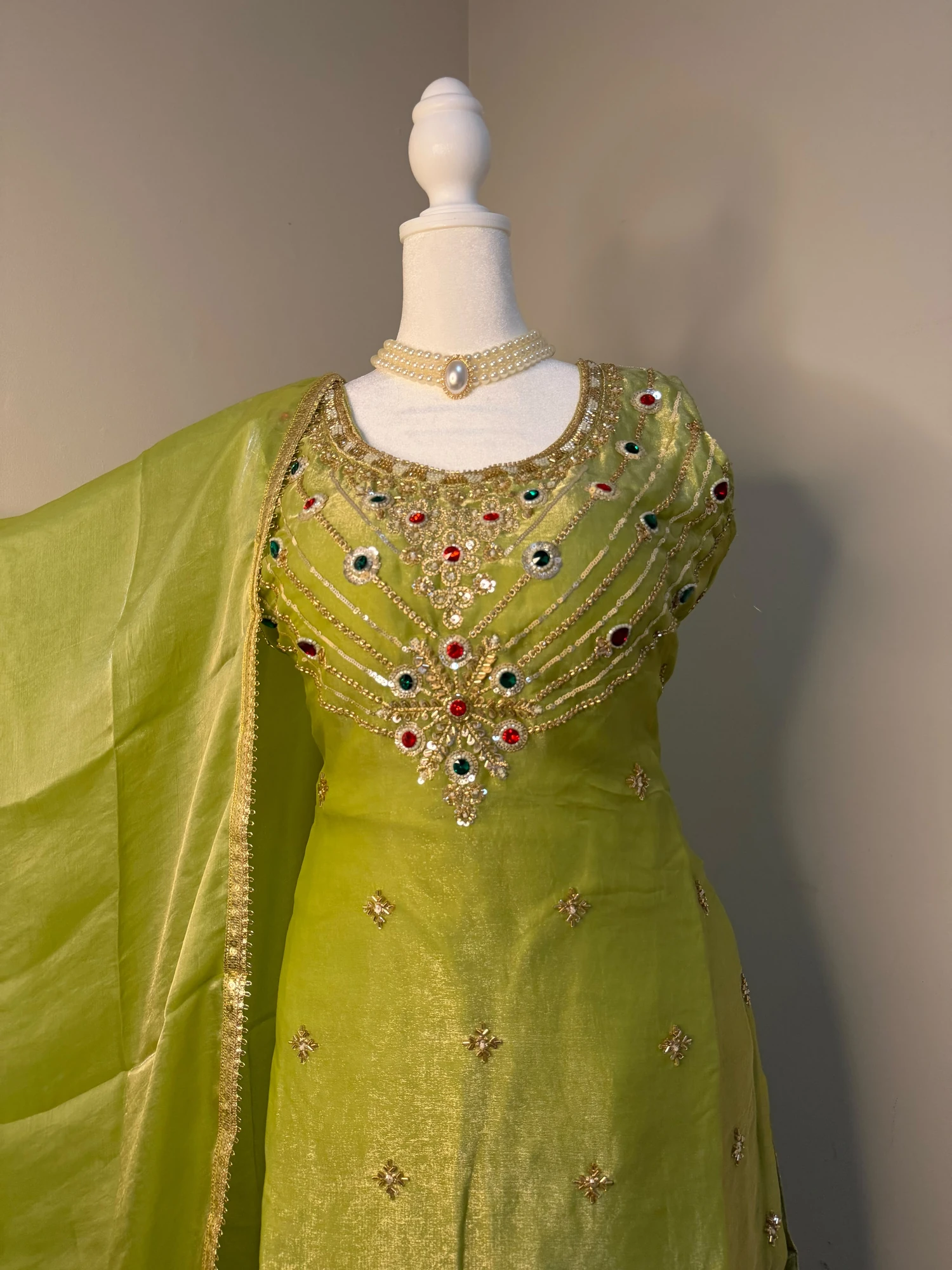 Detail of the lime-green outfit’s embellished neckline and bodice